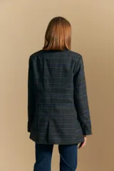 Blazer de corte sastrero con estampado de cuadros en tonos beige, marrones y rojizos. Presenta solapas clásicas, cierre frontal con un botón y bolsillos laterales con solapa.