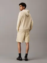 Shorts color beige de algodón texturizado con cintura elástica ajustable con cordón, bolsillos laterales y bolsillo trasero.