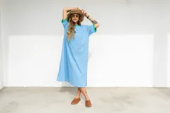 Vestido largo marrón con cuello redondo y mangas cortas con ribete amarillo. Estampado frontal con letras en color crema.