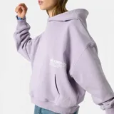 Hoodie oversize color lila con capucha y estampado en la espalda con el logo de Eme Studios y texto que dice "Always grateful for my roots, crafted with care 5135, Veteran Collection".
