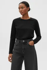 Remera de manga larga, color negro, con cuello redondo y un bolsillo de parche en el pecho.