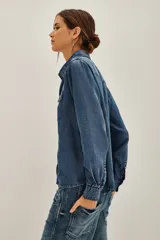 Camisa de estilo tejano en color negro lavado, con cuello camisero, cierre frontal con botones metálicos y dos bolsillos delanteros con solapa.