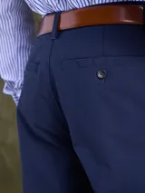 Pantalón de vestir color azul marino, de corte recto y estilo clásico, con bolsillos laterales y cierre frontal.