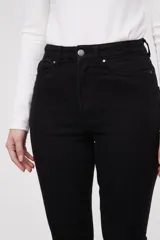 Pantalon jean de tiro alto con corte flare y terminación desflecada en el ruedo. Presenta un diseño clásico de cinco bolsillos con costuras en contraste.