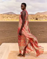 Vestido largo y fluido de seda lurex con estampado estilo pañuelo, cuello halter con lazo y diseño sin mangas.