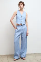 Pantalón de vestir color beige, de corte recto y tiro alto, confeccionado en lino 100% con bolsillos laterales.