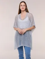 Poncho de tejido crochet gris claro con hilos metalizados de lúrex, corte amplio y fluido, con escote en V y mangas cortas integradas.