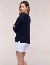 Buzo liviano de algodón con tejido de punto abierto y semi holgado, color beige, con escote bote, mangas largas de hombros caídos y costuras expuestas.