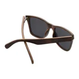 Lentes de sol Indie Forest Nogal Burl con montura cuadrada de acetato color marrón con efecto madera y lentes grises polarizadas.