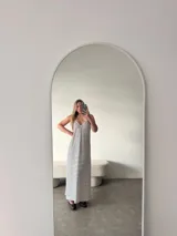 Vestido largo de jersey, color negro con rayas horizontales blancas, corte recto y tirantes finos.