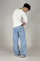 Pantalón jean celeste de corte amplio, estilo cargo, con bolsillos laterales y traseros.