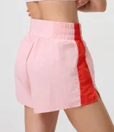 Bermuda runner deportiva de microfibra, con diseño bicolor en tonos rosado y rojo, calce holgado, cintura elástica y bajo redondeado.