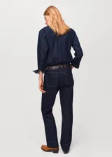 Pantalón de jeans de corte recto y tiro medio con cierre frontal de cremallera y botón, trabillas para cinturón y bolsillos.