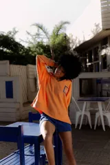 Buzo amarillo de algodón con cuello polo y bordes en azul. Presenta un bordado en el pecho con un diseño de sello postal.