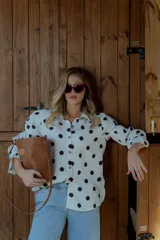 Cartera tipo canasto color marrón, con forma de cubo y diseño tejido. Incluye una bolsa interior de tela color chocolate con cierre.