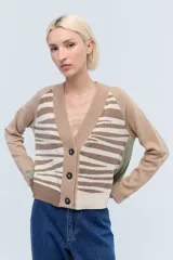 Cardigan de tejido de punto color beige con estampado de cebra en el cuerpo y mangas largas.