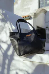 Cartera tote de cuero color marrón con doble asa de hombro y etiqueta con el logo de la marca "Soriame" en el frente.