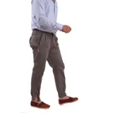 Pantalón de vestir azul marino, de corte recto, con bolsillos laterales y traseros. Se ajusta a la cintura con cinturón de cuero marrón. Tiene un cierre con botones en el tobillo.