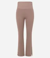 Pantalón deportivo de tiro alto con corte flare, confeccionado en microfibra elástica. Presenta un diseño ajustado en caderas y muslos con una apertura acampanada desde la rodilla y detalle de tajo lateral en el ruedo.