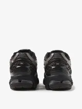 Championes New Balance modelo 1906R, de diseño técnico y retro-futurista. Presentan una base de malla transpirable con superposiciones texturizadas en tonos marrones y grises. Incorporan tecnología ABZORB en la mediasuela y sistema N-ergy para una amortiguación superior.