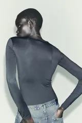 Body de manga larga confeccionado en mezcla de poliamida, con cuello redondo y cierre inferior con botones a presión.