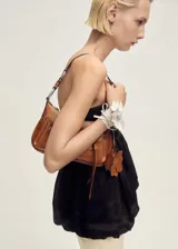 Top strapless de corte estilo globo con bajo abullonado, confeccionado en tejido de ramio con forro de viscosa y cierre de cremallera en la parte posterior.