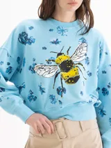 Buzo de algodón gris con estampa de abeja en el centro y diseño de flores oscuras dispersas por toda la prenda. Cuenta con cuello redondo, mangas largas y puños y cintura elastizados.