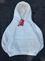 Hoodie de color blanco off-white con diseño de capucha, bolsillo frontal tipo canguro y bordado en relieve con el texto ITTAI STARS y un logo caligráfico.