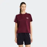 Remera Adidas de la línea Originals, confeccionada en tejido tricot color bordó. Presenta cuello redondo, corte holgado y las icónicas tres rayas de la marca en los hombros. Incluye el logo del trifolio bordado en el pecho.