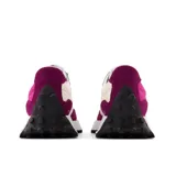 Championes New Balance modelo 327, de dama, con diseño multicolor en fucsia, morado, blanco, verde menta y negro. Presentan una entresuela ensanchada, empeine de ante y malla, y una marca "N" de gran tamaño aplicada asimétricamente. La suela tiene un relieve inspirado en el trail.