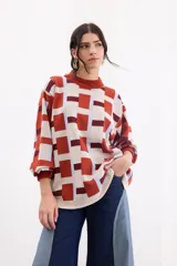 Sweater de tejido de punto con diseño geométrico a cuadros en tonos beige, terracota, bordó y celeste, de corte holgado, manga larga y cuello redondo.