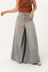 Jean súper campana de tiro alto, color celeste vintage, con pierna extra ancha y caída fluida. Cuenta con bolsillos delanteros y traseros, y cierre frontal con cremallera y botón metálico.