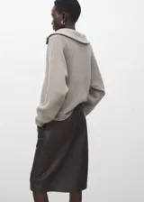 Jersey de punto gris con cuello solapa y escote en V, de manga larga y diseño holgado.