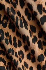 Blusa de corte holgado con estampado animal print de leopardo, escote redondo, mangas largas amplias y diseño recto.