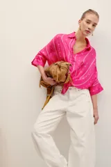 Camisa de seda color fucsia, con diseño estampado geométrico y de manga tres cuartos.