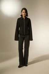 Sobrecamisa de jean color negro con cierre frontal, cuello clásico y detalle de cordones laterales ajustables con ojalillos metálicos.