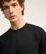 Remera masculina color blanco hueso, modelo boxy, con cuello redondo y mangas cortas. Confeccionada con tecnología Dry para un tacto frío en el interior y algodón en el exterior.