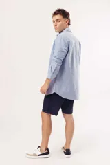 Camisa de manga larga para hombre, color azul claro jaspeado, con cuello clásico y botones blancos. Corte ajustado (slim fit).