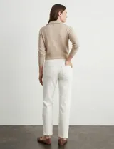 Pantalón tipo jegging de denim color blanco roto, tiro alto, corte recto al tobillo con cierre funcional en el ruedo. Diseño pull-on sin cierre ni botón frontal, con bolsillos funcionales traseros y simulados delanteros.