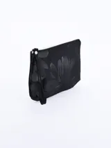 Neceser rectangular negro con estampado de flores en tono más oscuro. Posee cierre superior plateado y correa de mano desmontable.