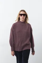 Polera gris de tejido suave de punto, con cuello alto, mangas abullonadas, puños elásticos y diseño relajado.