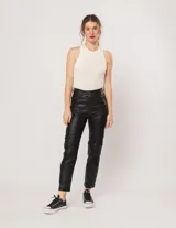 Pantalón negro estilo jeanero confeccionado en gabardina elastizada con terminación metalizada, pierna recta con largo por arriba del tobillo, cierre delantero y botón.