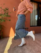 Falda midi de jean celeste con corte recto y abertura frontal.