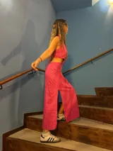 Vestido largo fucsia con espalda descubierta y aberturas laterales en la cintura.