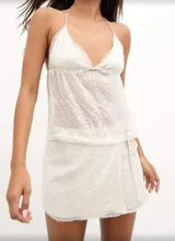 Top blanco con lentejuelas, breteles finos y escote en V.