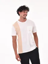 Remera de corte oversize, con diseño bicolor que combina blanco y beige. Presenta un bolsillo frontal en el pecho con el logo de la marca bordado y una etiqueta pequeña en el ruedo.