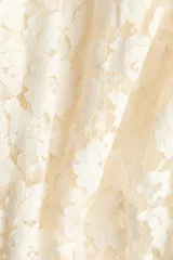 Pollera midi de encaje color beige, de corte holgado con cintura elástica y volado ancho en la parte superior.