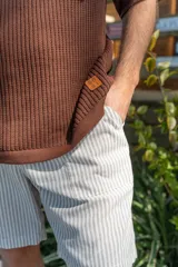 Bermuda de lino imperial a rayas verticales blancas y grises, con bolsillos laterales y traseros y elástico en la cintura.