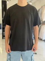 Remera oversize de manga corta en color negro con efecto gastado o acid wash, cuello redondo y diseño liso.