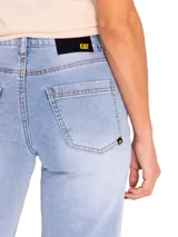 Jeans de corte recto y tiro medio, color celeste claro con efecto lavado. Presenta diseño de cinco bolsillos, cierre frontal con cremallera y botón, y detalles de roturas desgastadas en la pierna izquierda y cadera derecha.